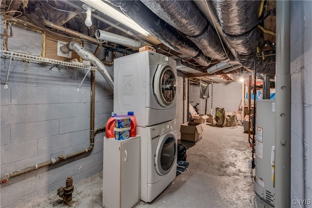 laundry room featuring water heater and stacked washer / dryer