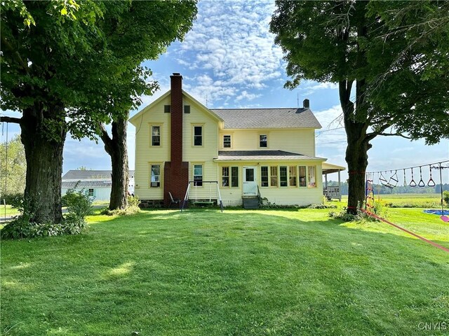 rear view of property featuring a yard