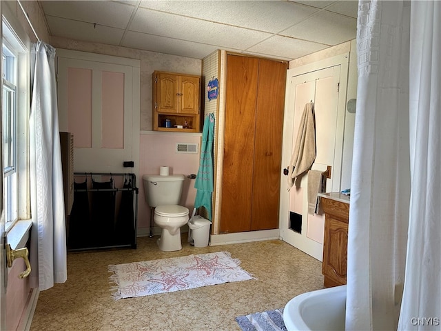 bathroom with a paneled ceiling, toilet, and vanity