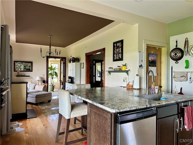 kitchen featuring light hardwood / wood-style floors, stainless steel dishwasher, sink, and dark brown cabinetry