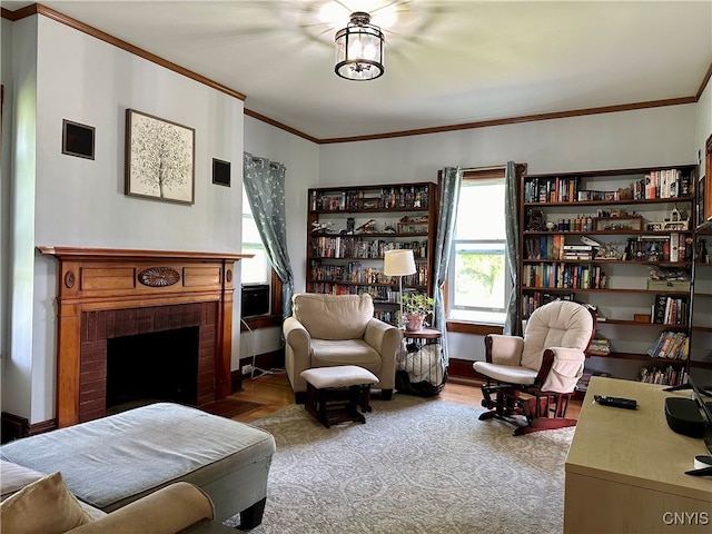 living room with a brick fireplace, crown molding, and hardwood / wood-style floors