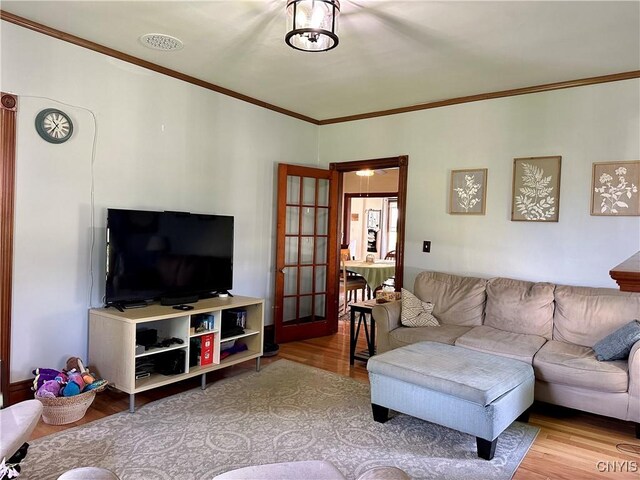 living room with ornamental molding and light wood-type flooring