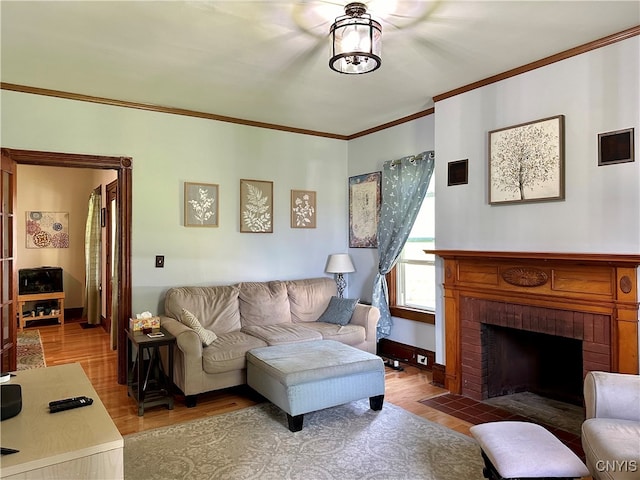 living room with a fireplace, ornamental molding, and wood-type flooring