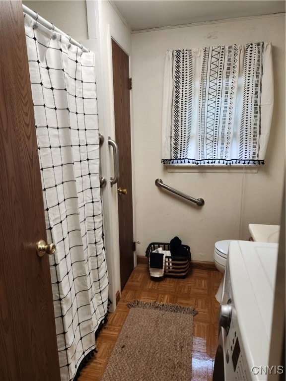 bathroom with parquet flooring, toilet, and a shower with shower curtain