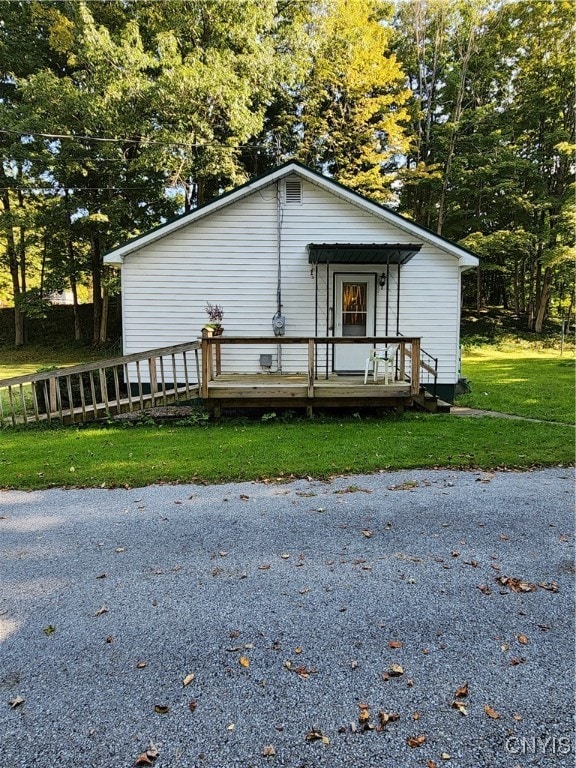 view of front of house with a deck and a front yard