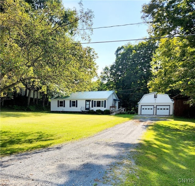 view of front of house featuring an outbuilding, a garage, and a front yard