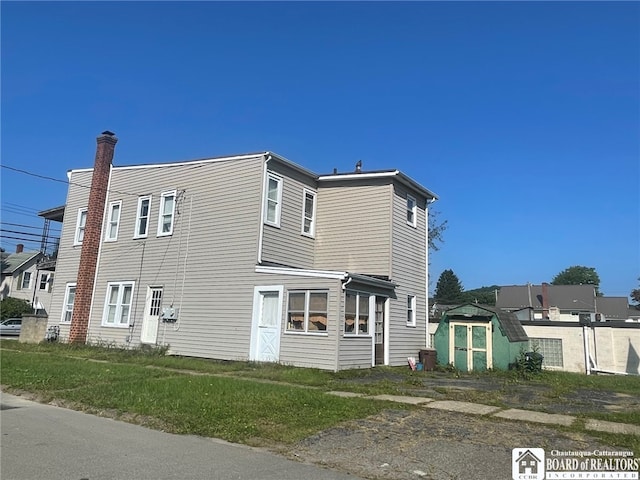 view of front of home featuring a storage unit, cooling unit, and an outbuilding