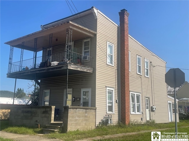 view of side of home featuring a balcony and a porch