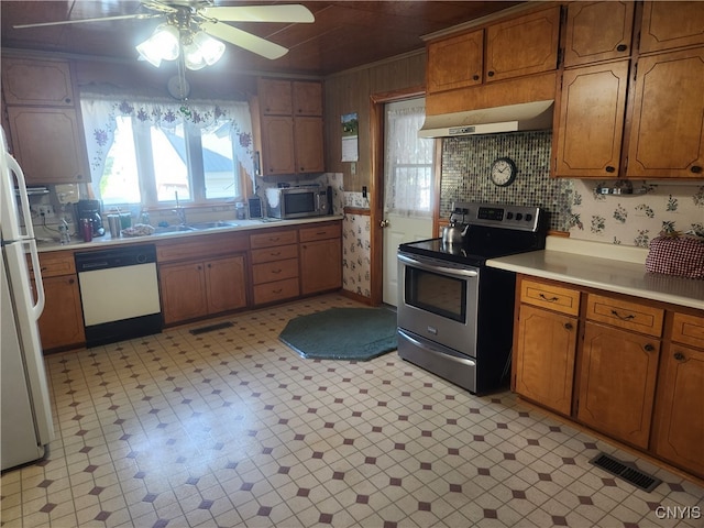 kitchen with appliances with stainless steel finishes, decorative backsplash, sink, crown molding, and ceiling fan