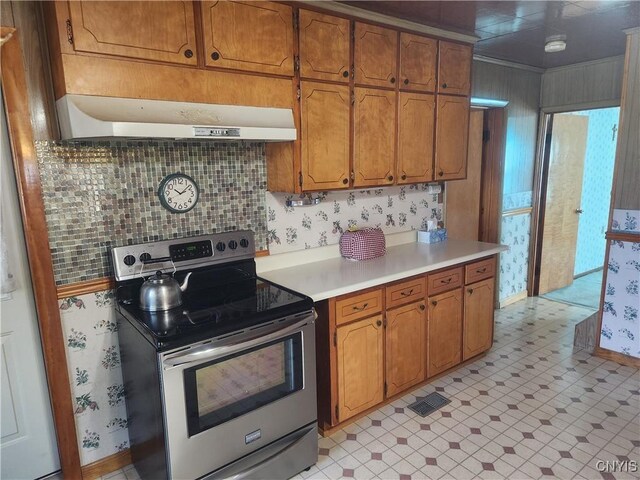kitchen featuring electric range, extractor fan, light floors, and light countertops