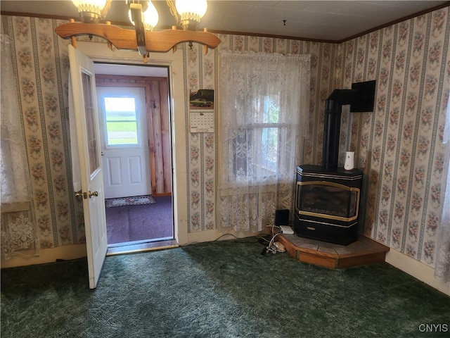 interior space with carpet, a notable chandelier, crown molding, and a wood stove