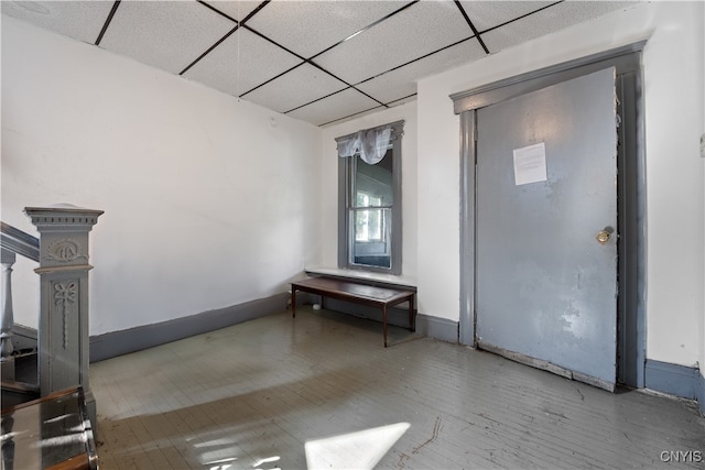 interior space with a drop ceiling and wood-type flooring