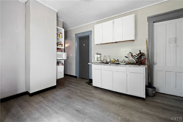 kitchen with white cabinets, sink, and hardwood / wood-style floors