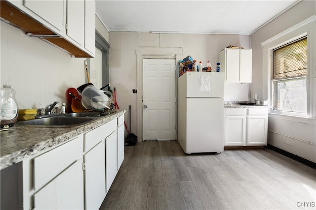 kitchen featuring light hardwood / wood-style flooring, white cabinetry, and white fridge