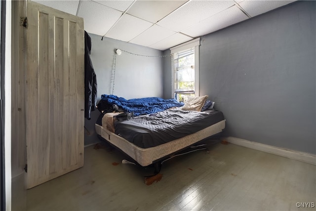 bedroom with hardwood / wood-style flooring and a paneled ceiling