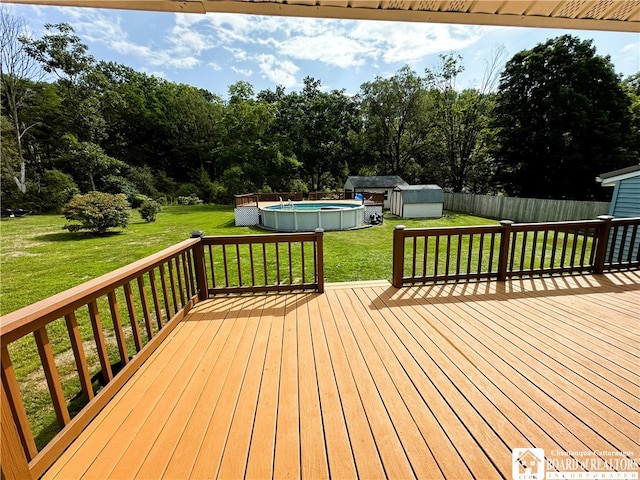 wooden terrace with a fenced in pool and a lawn