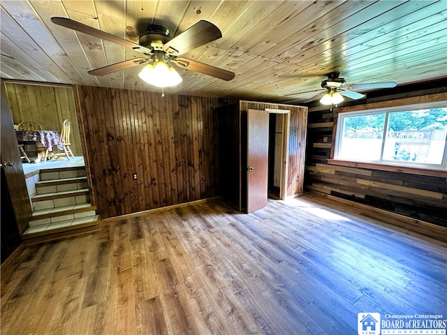 unfurnished bedroom featuring wood ceiling, wood walls, and wood-type flooring