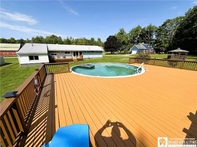 view of pool featuring a wooden deck, a lawn, and a jacuzzi