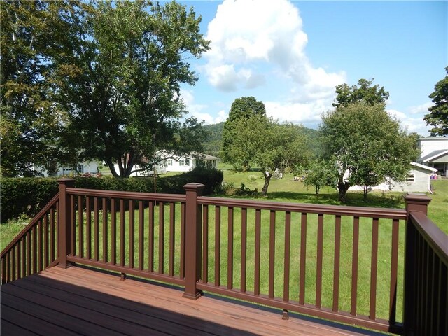 wooden terrace featuring a lawn