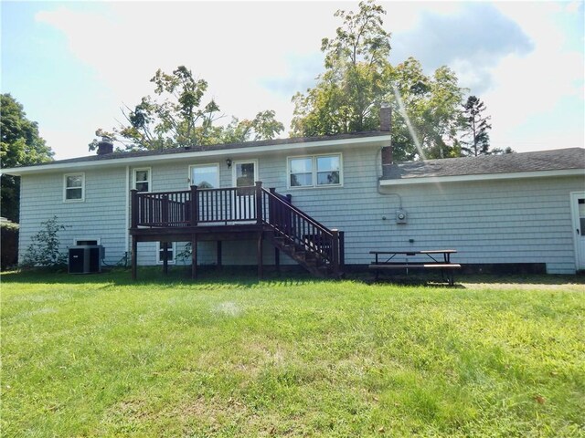 back of property with a wooden deck, central AC unit, and a yard