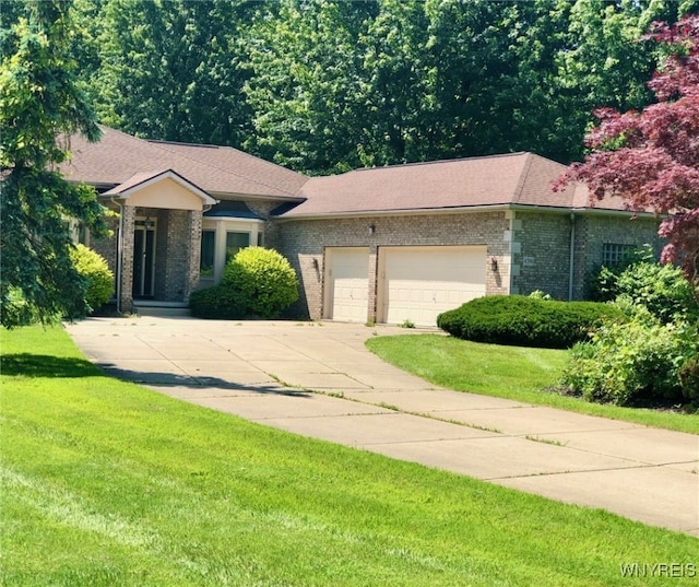 view of front of house featuring a garage, driveway, a front lawn, and brick siding