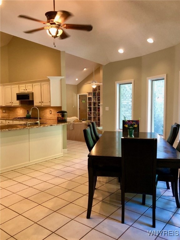 dining area featuring light tile patterned floors, ceiling fan, vaulted ceiling, and recessed lighting