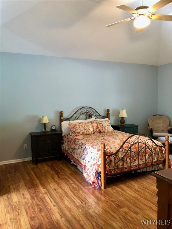 bedroom featuring lofted ceiling, baseboards, a ceiling fan, and wood finished floors