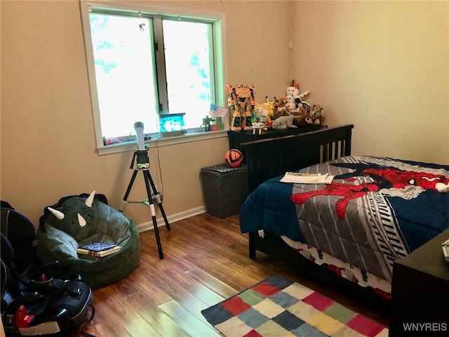 bedroom featuring multiple windows and wood finished floors