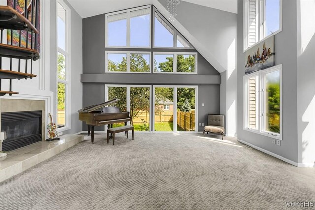 living room featuring high vaulted ceiling, carpet, and a fireplace