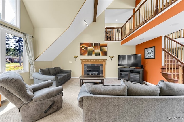 carpeted living room featuring a wealth of natural light, a high ceiling, and a tiled fireplace