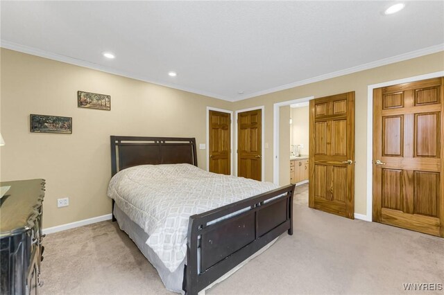 bedroom with connected bathroom, crown molding, and light colored carpet