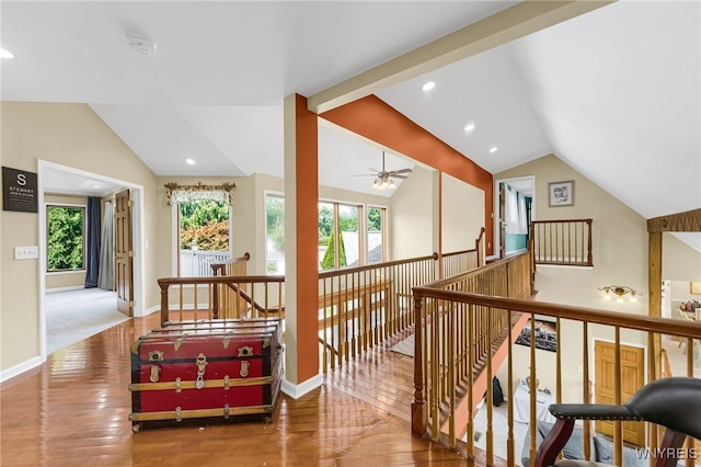 hall with lofted ceiling, wood-type flooring, and a wealth of natural light