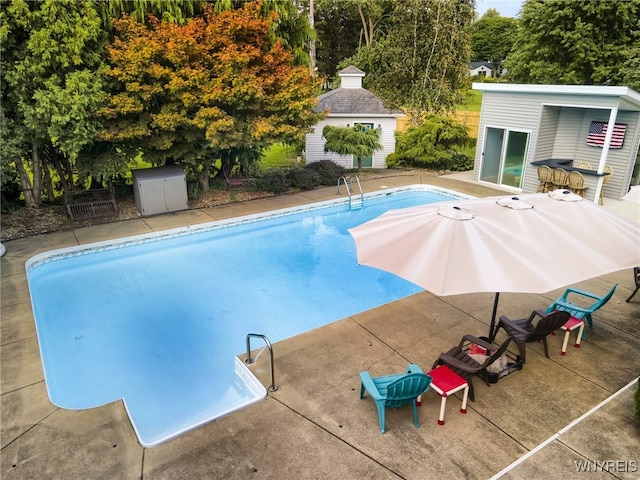 view of swimming pool featuring an outdoor structure and a patio