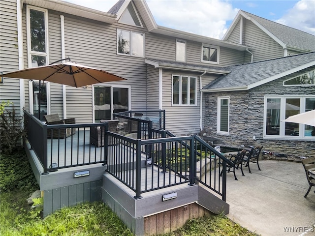 back of property featuring a patio area and a deck