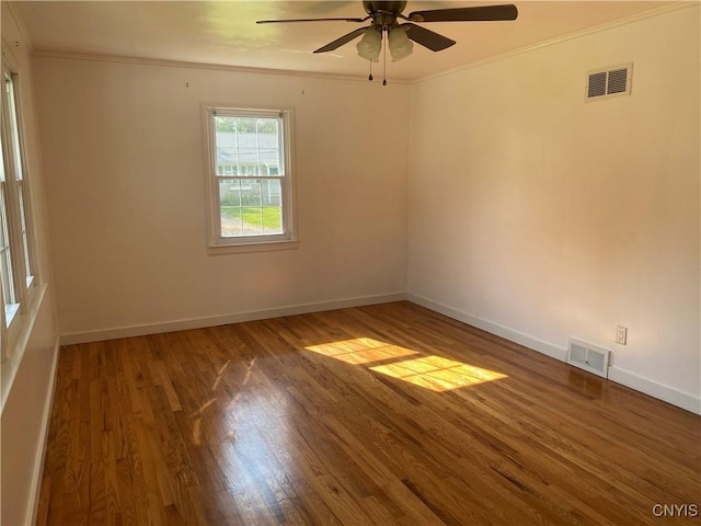 unfurnished room with visible vents, wood finished floors, and ornamental molding