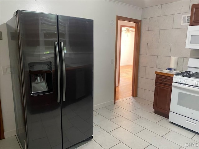 kitchen with light countertops, white appliances, visible vents, and tile walls