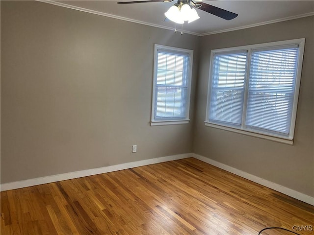 unfurnished room featuring ceiling fan, ornamental molding, wood finished floors, and baseboards