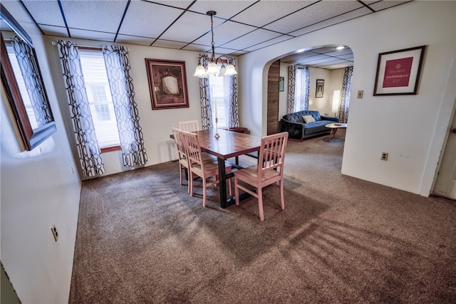 carpeted dining room featuring a drop ceiling