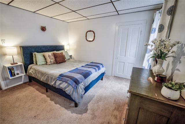 bedroom featuring light carpet, a closet, and a drop ceiling