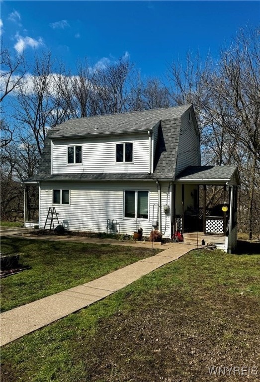 rear view of property featuring a lawn