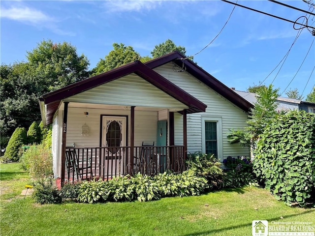 bungalow-style home featuring covered porch and a front lawn