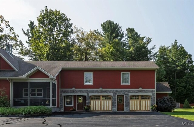 rear view of property featuring a sunroom