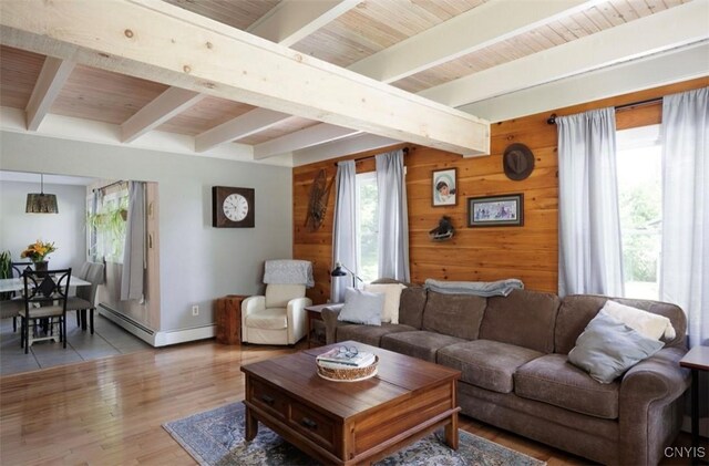 tiled living room featuring wood walls, baseboard heating, plenty of natural light, and beamed ceiling