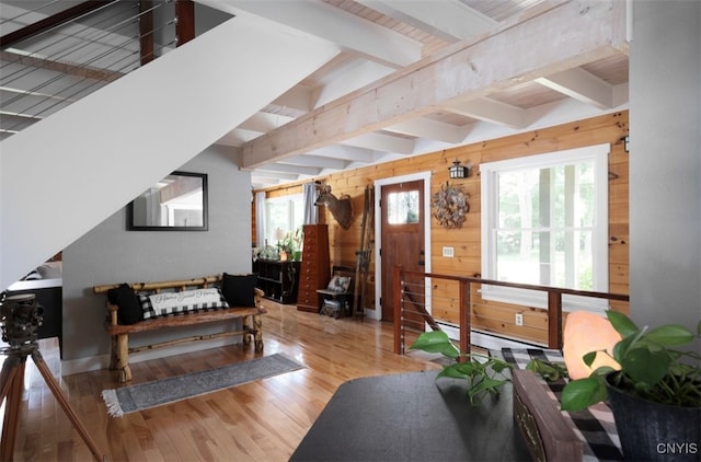 interior space featuring wood walls, beamed ceiling, and wood-type flooring