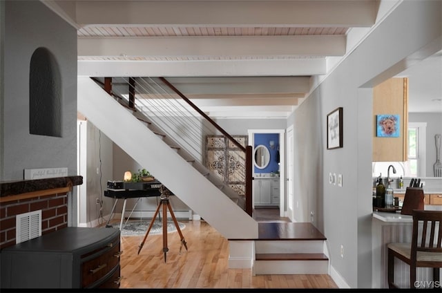 entryway with light wood-type flooring and beam ceiling