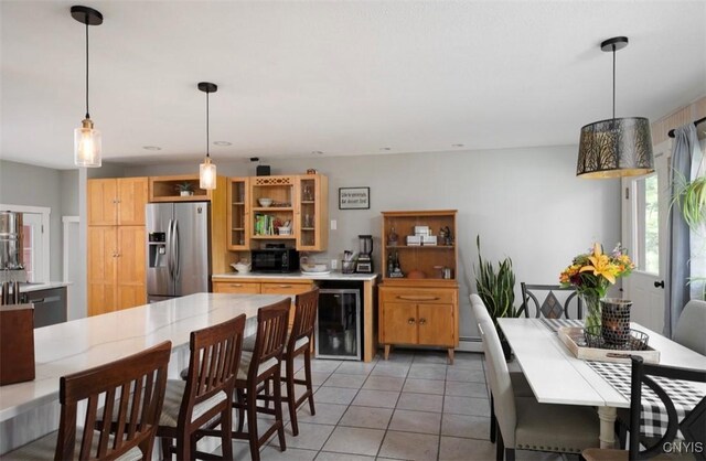 kitchen with stainless steel refrigerator with ice dispenser, beverage cooler, tile patterned flooring, hanging light fixtures, and baseboard heating