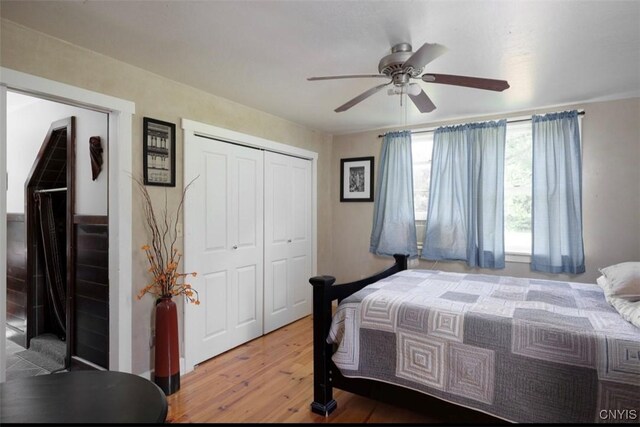 bedroom featuring hardwood / wood-style flooring, ceiling fan, and a closet