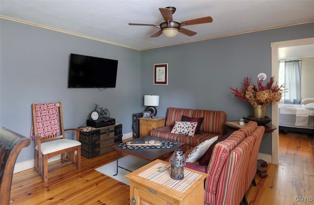 living room featuring ceiling fan, light hardwood / wood-style floors, and ornamental molding