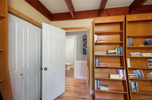 interior space with ensuite bath, a closet, beam ceiling, and light hardwood / wood-style floors