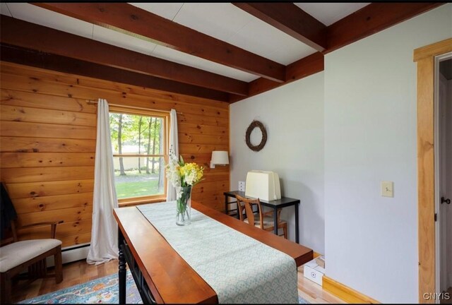 dining space with beamed ceiling and hardwood / wood-style floors